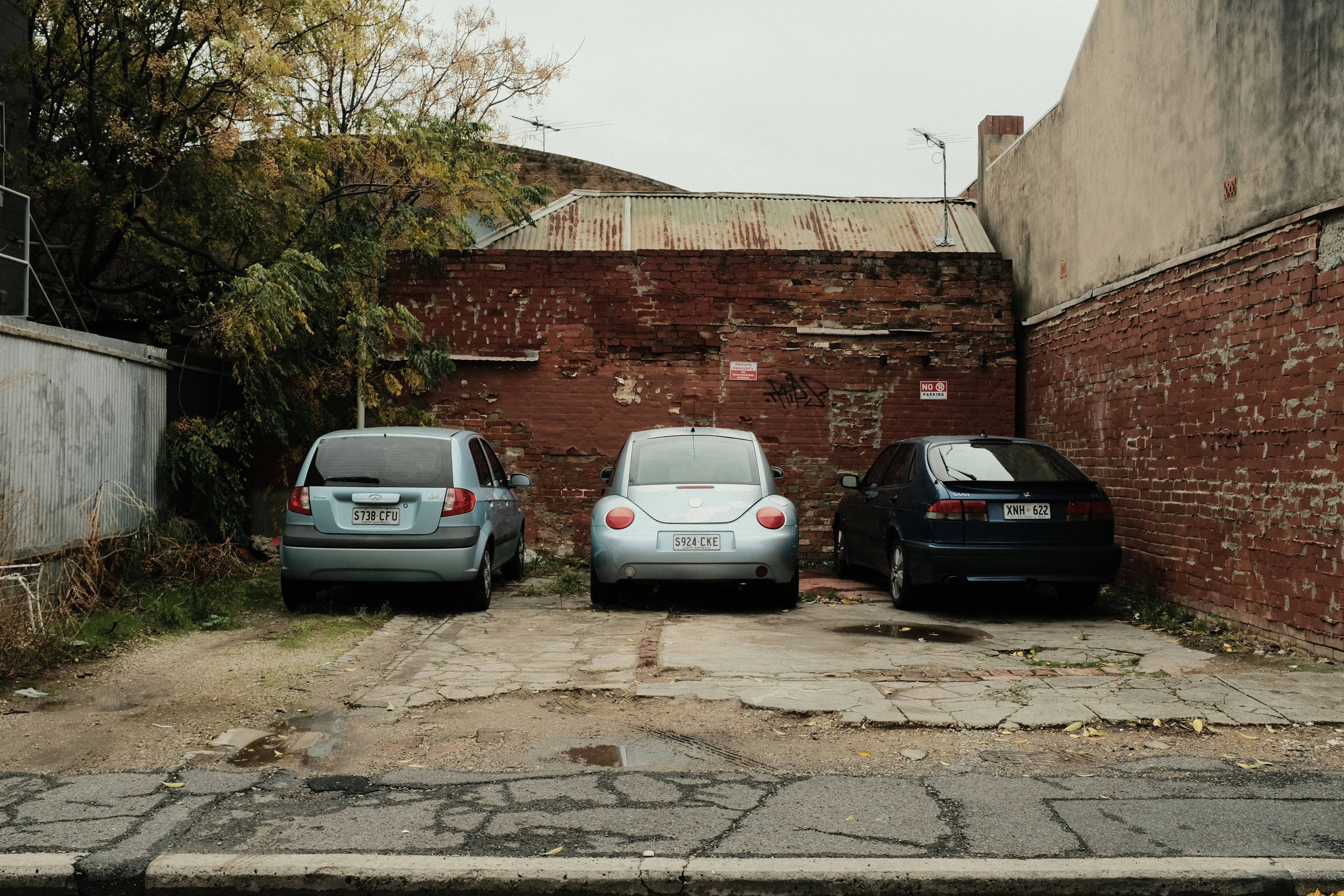 Used cars parked against a brick wall - vehicles that might need warranty protection